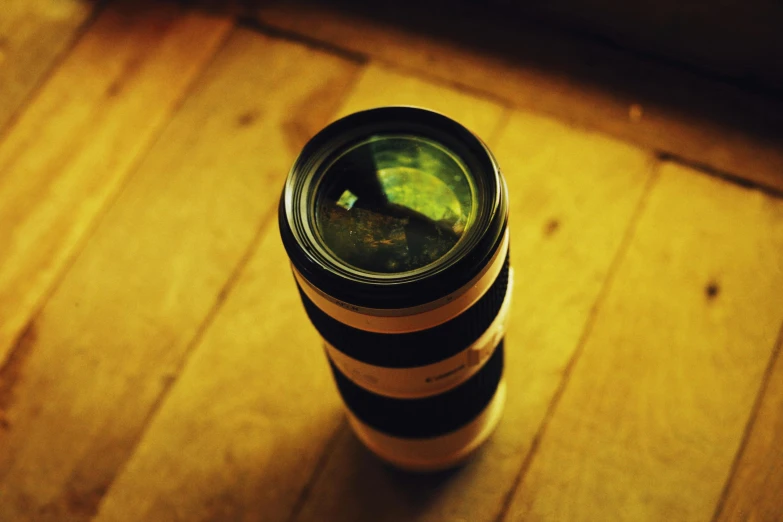 a camera lens laying on top of a wooden surface