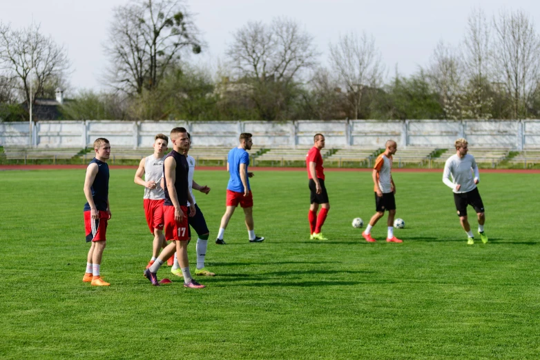 men walking and playing soccer on an outdoor grass court