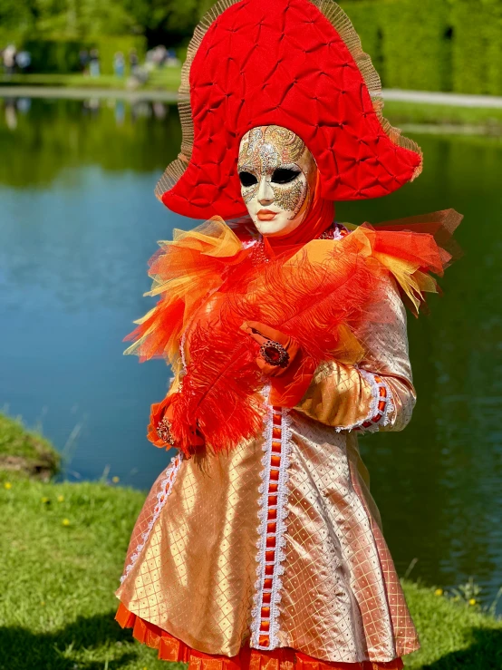 a woman wearing a carnival make - up holding a big bird