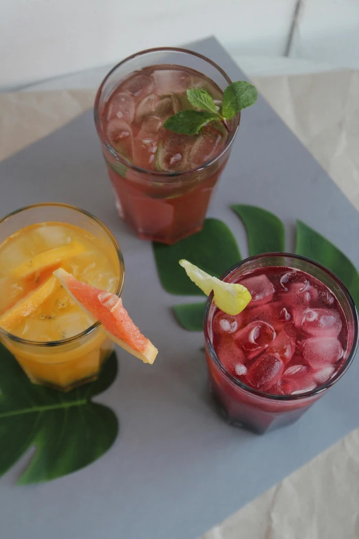 three drinks that are on top of a gray mat