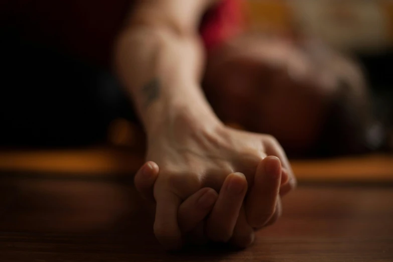 a persons hand resting on a table in the room