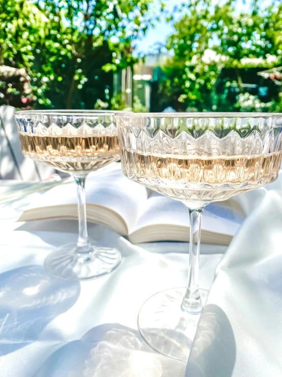 two martini glasses are sitting on an outdoor table