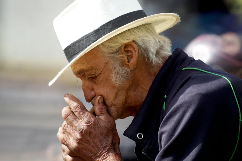 an older man is holding his hand over his face