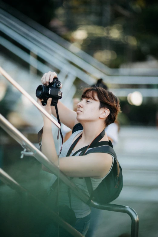 an asian woman taking a pograph with a camera