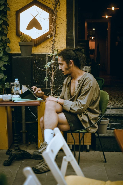 a man sitting in a chair looking at his laptop