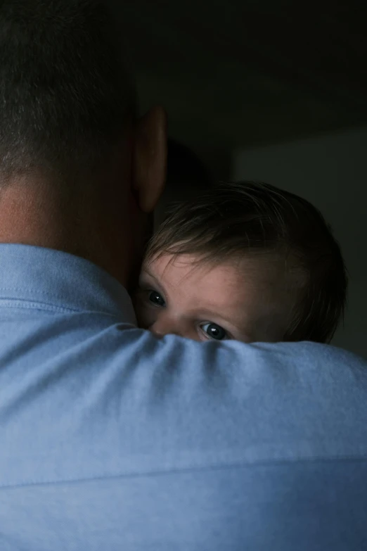 a man holding his face against his shoulder