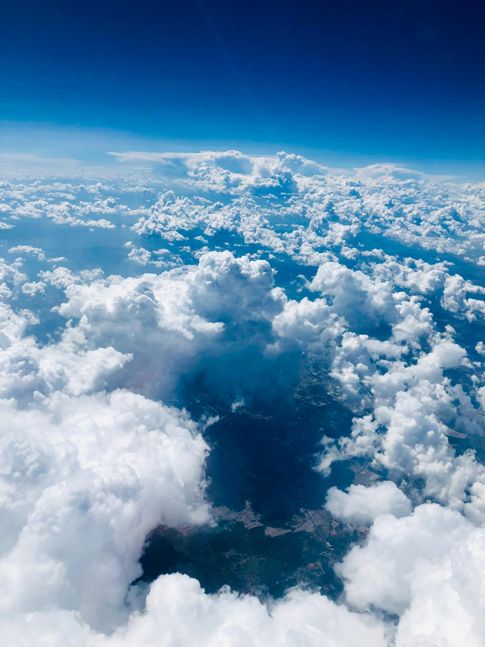 the view from the airplane shows an area surrounded by fluffy clouds