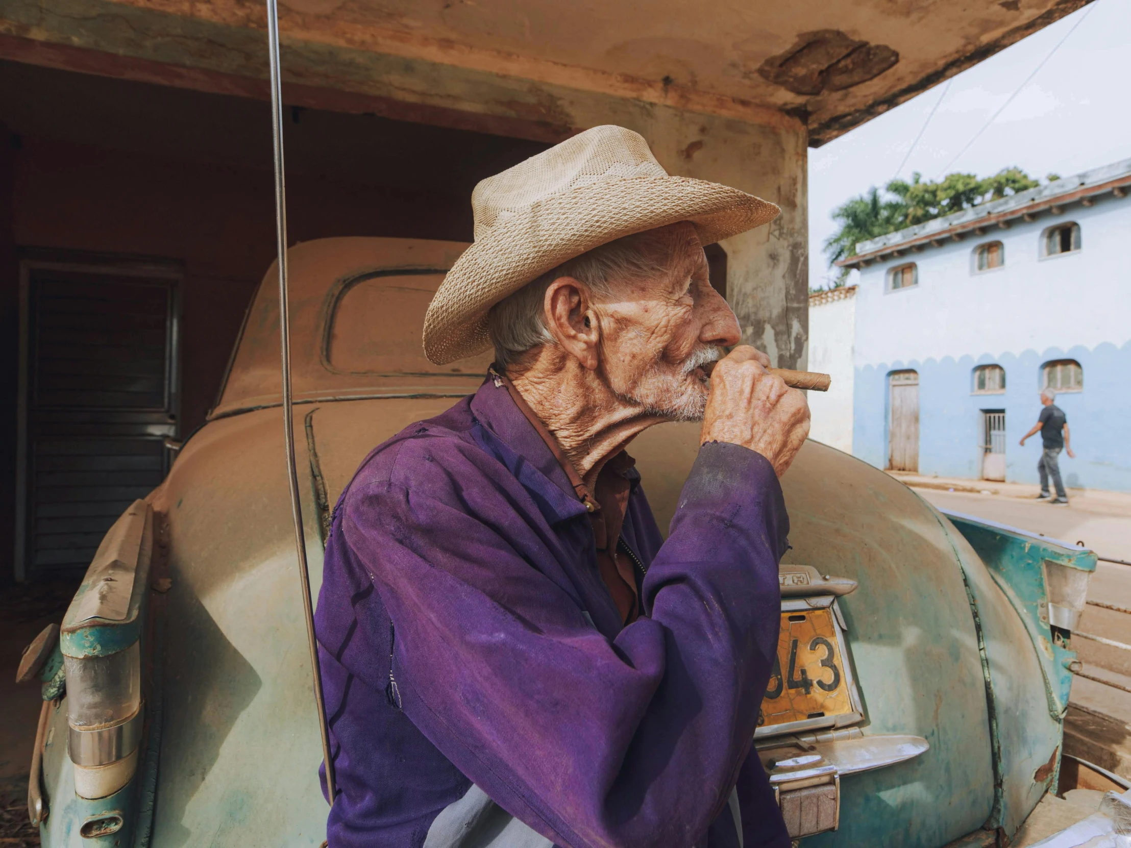 an old man smoking a cigarette outside in his car