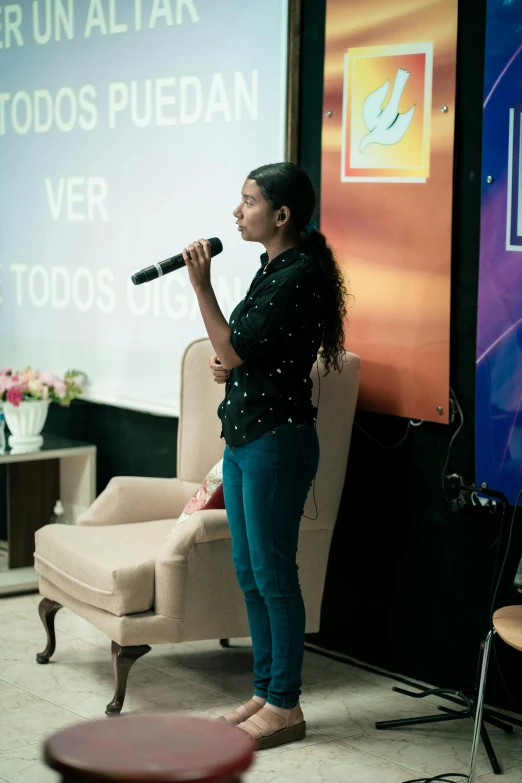 the woman is speaking into the microphone in a room