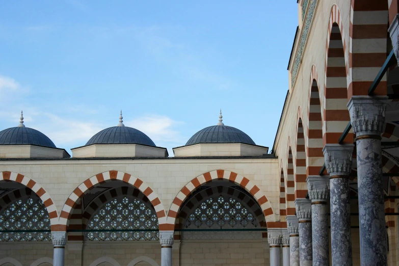 the dome tops on an elegant islamic building are red and tan