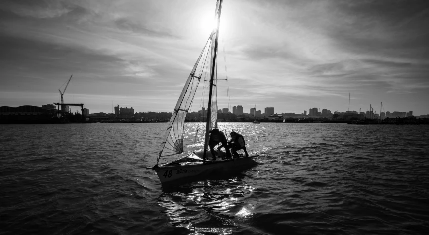 a black and white po of a small sailboat in a body of water