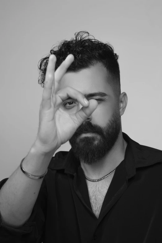 the man is posing for the camera with his hand to his temple