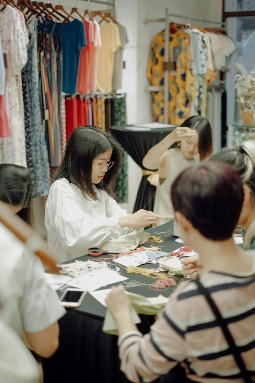 several women sitting at a table that is covered in pictures