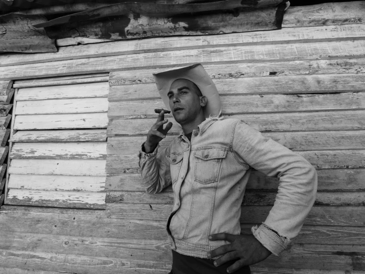 a man in a paper cap smoking on the street