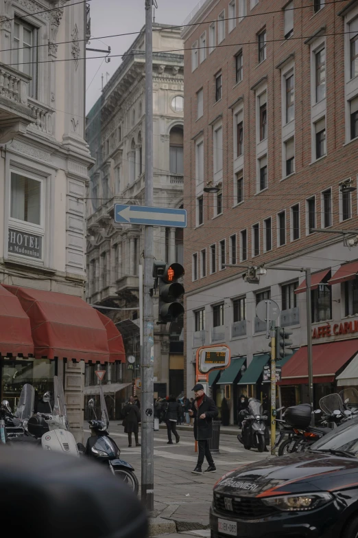 a man is standing on a corner where cars are driving on the road