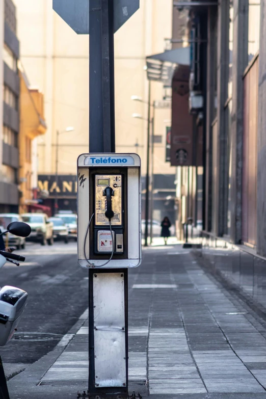 an old cell phone on the sidewalk of a city street