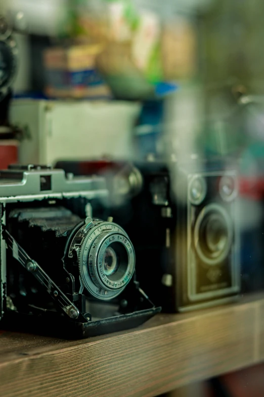 a mirror image of an old camera on a wooden shelf