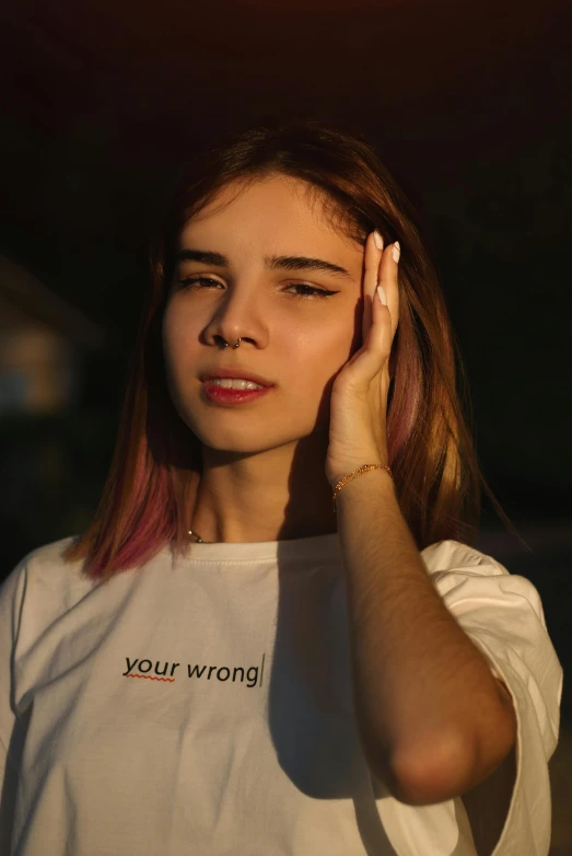 the woman is posing while holding her hands up to her ear