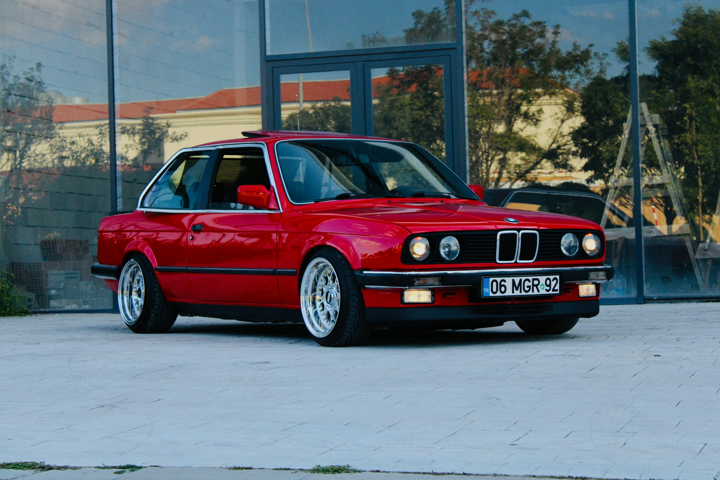 a red car sitting in front of a building