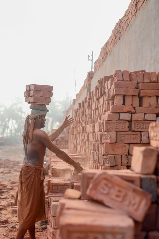 a woman carrying bricks on her head