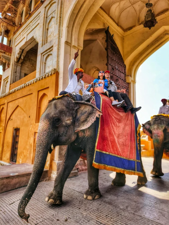 a group of people riding on the backs of elephants