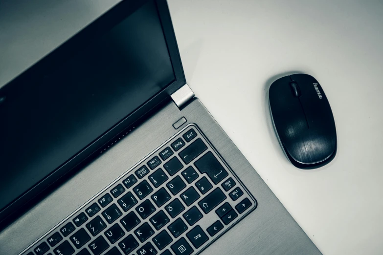 a laptop computer with a mouse on it next to a keyboard