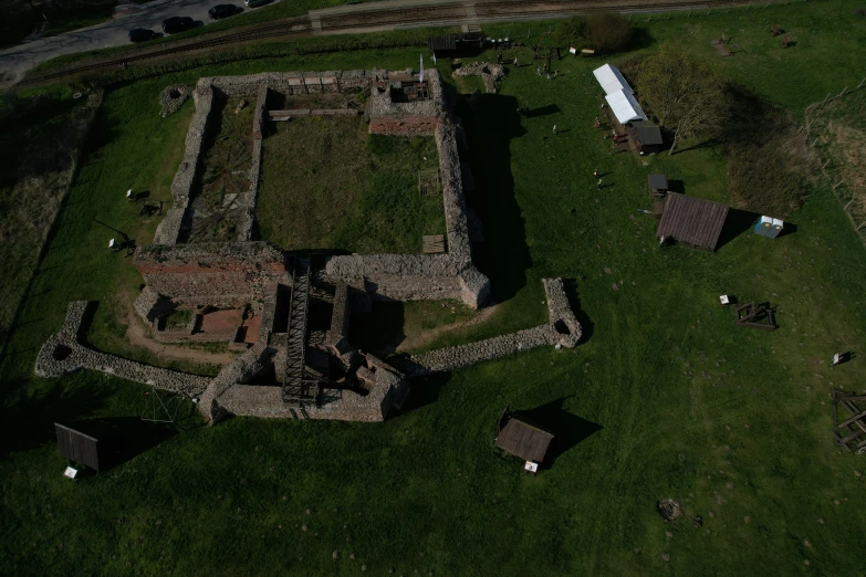 an aerial view of a building from above, surrounded by green grass