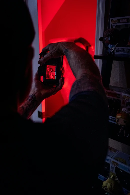 a man taking pictures in the dark, with red light