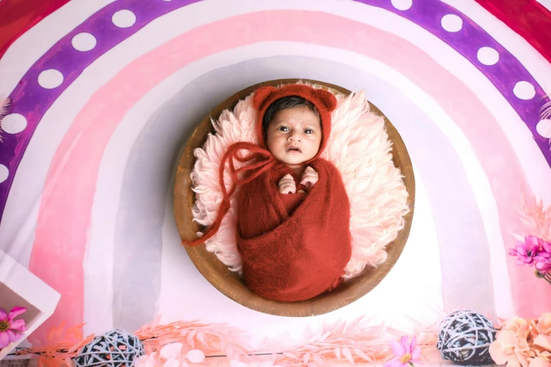 a small baby in a red coat and pink fluffy clothing