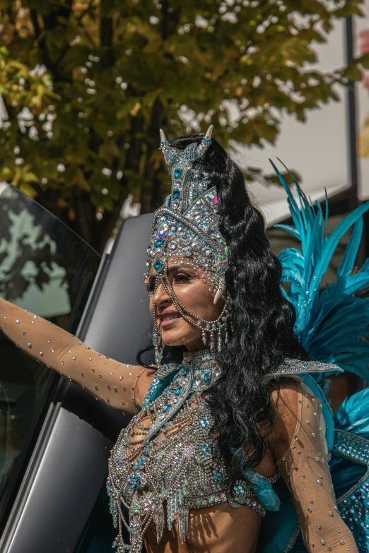 a woman in costume waving at soing out of her car