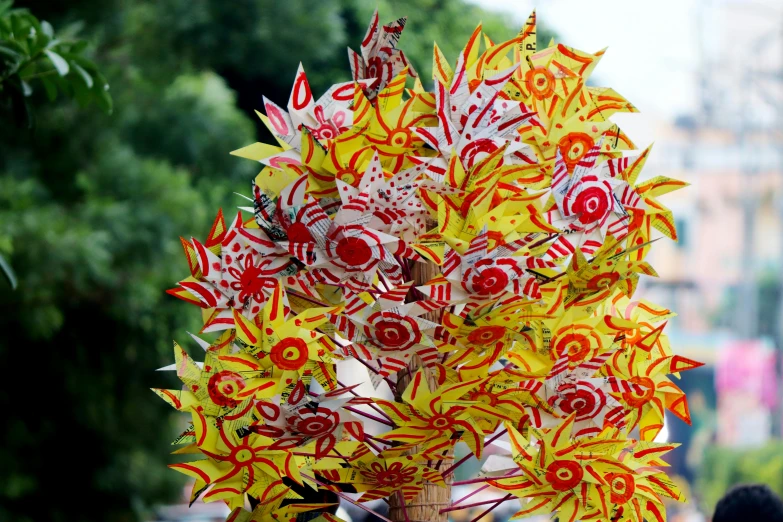 close up of red and yellow flowers on green nches