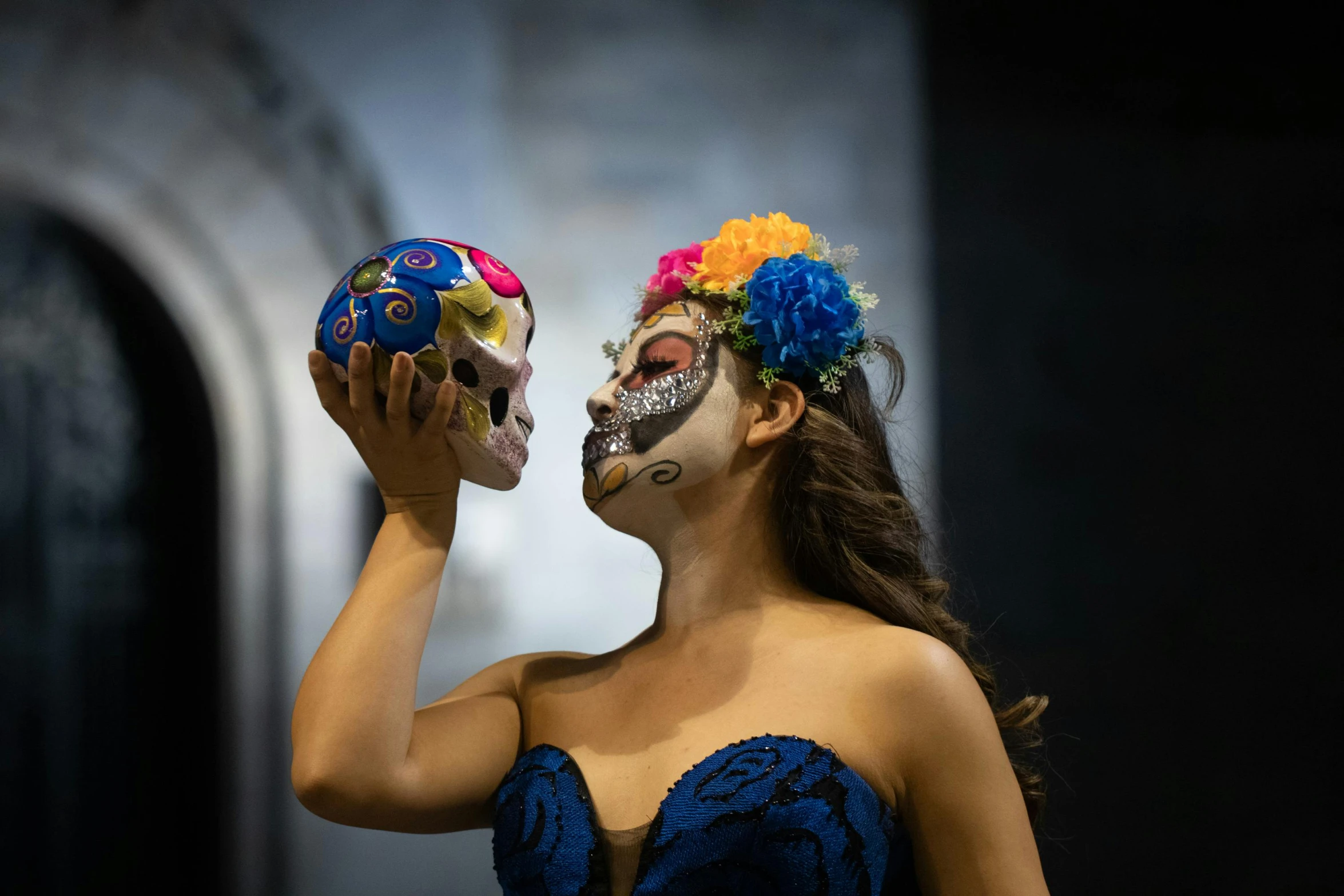 the woman is holding a skull that she's painted