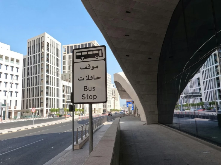 a bus stop sign next to buildings on a city street