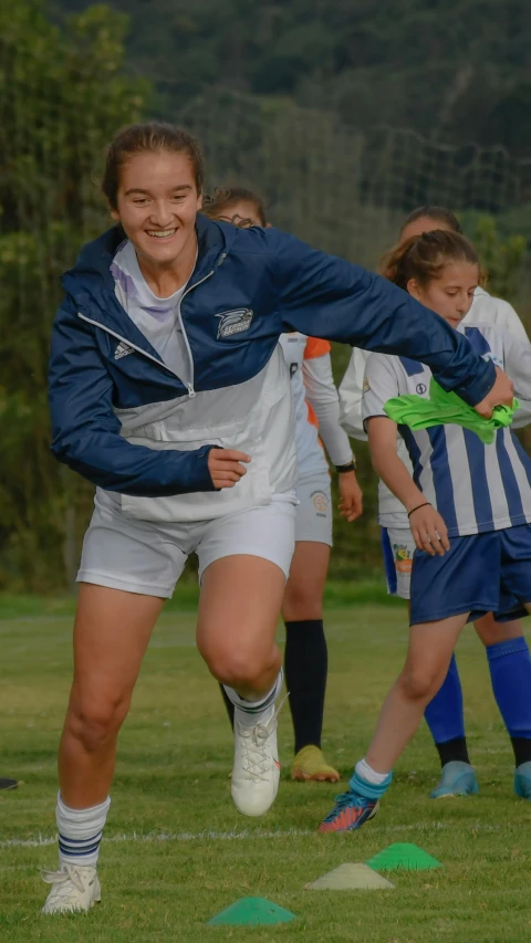 two girls running to kick the ball together