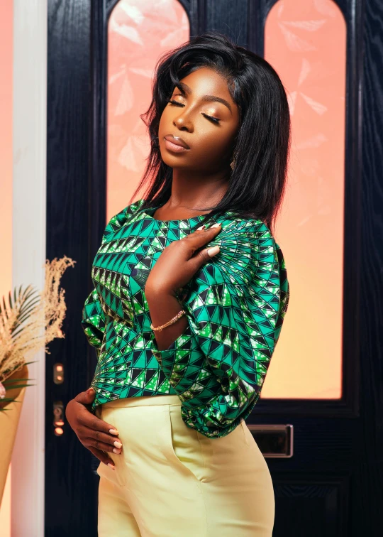 a woman is posing in front of a black door