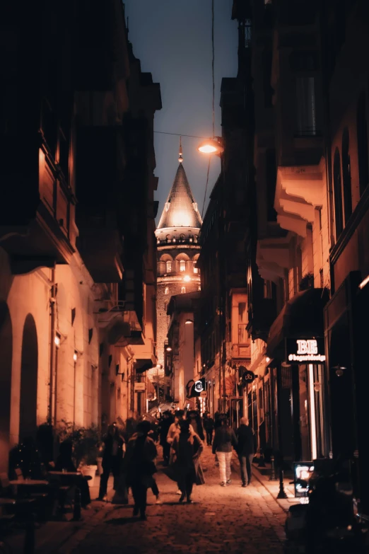 an old city street at night with people in the street
