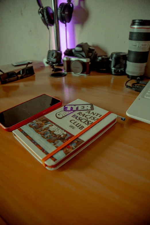 a table with a camera, cell phone and camera equipment