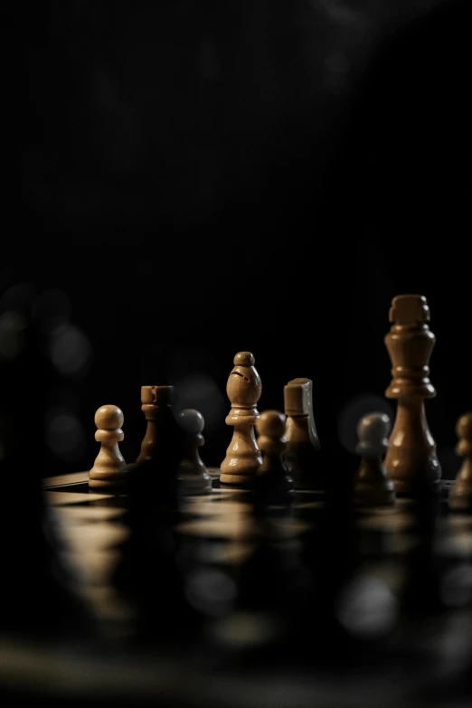 a group of wooden chess pieces sitting on top of a chess board