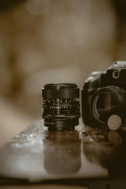 an old camera sitting on a table next to some glass