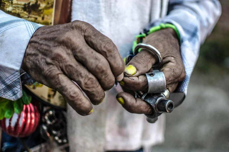 an old pair of hands holds a piece of jewelry