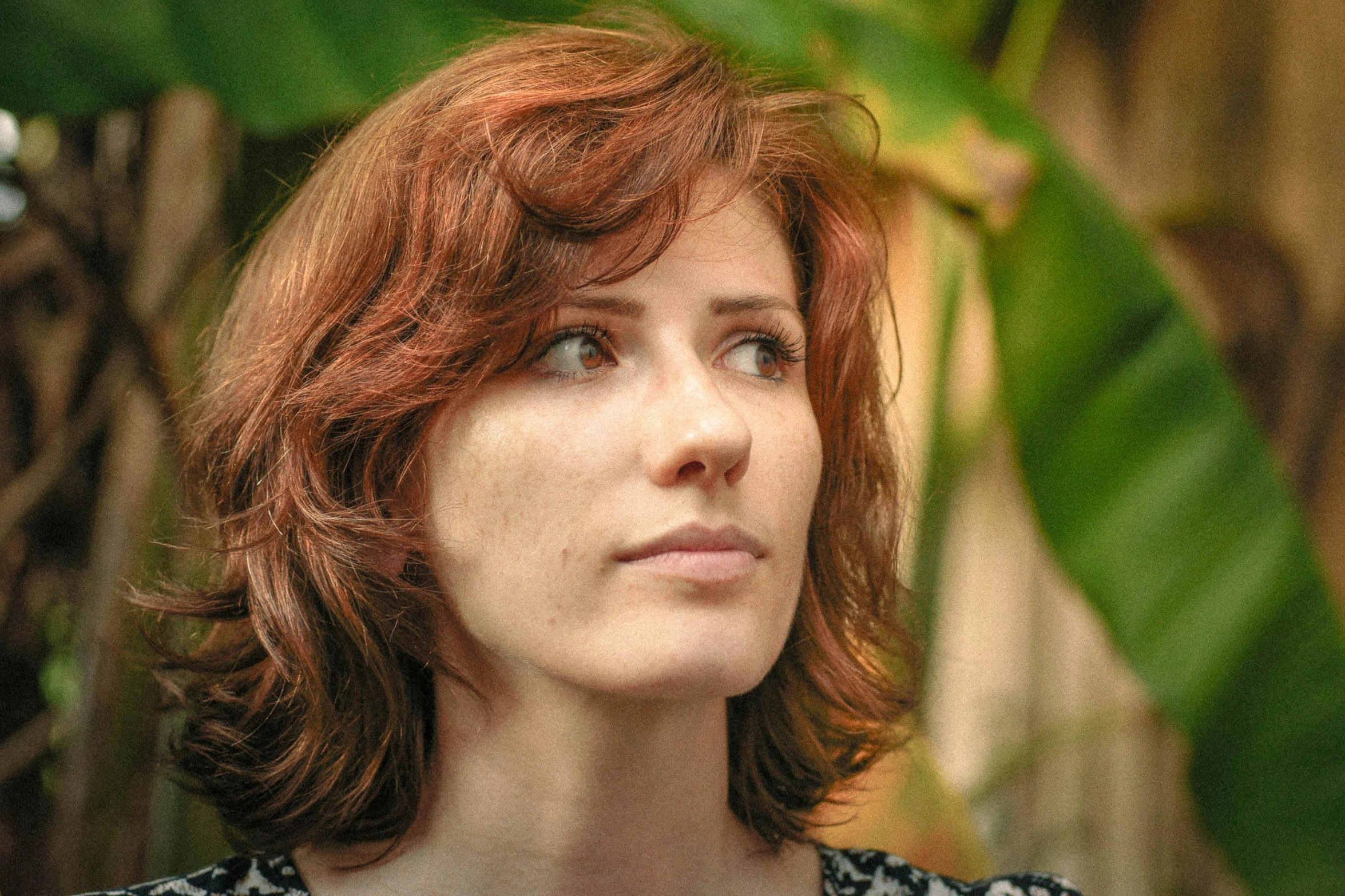 woman with shoulder length red hair staring intently at soing