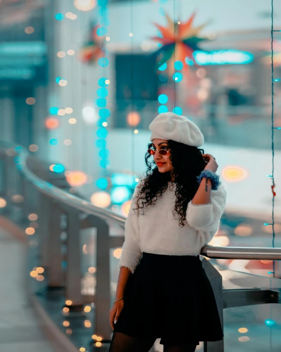 a woman in glasses and a white sweater talking on a cell phone