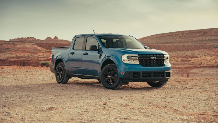 a blue pickup truck sitting in the desert