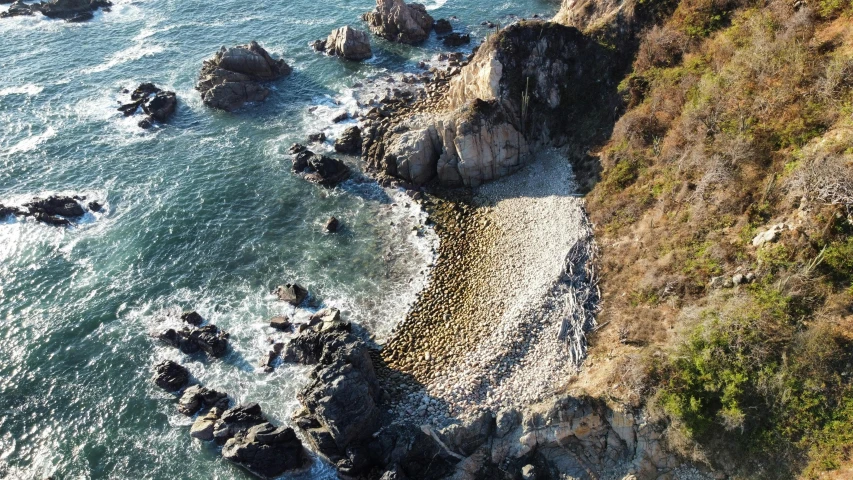 an aerial view of a rocky coast next to some water