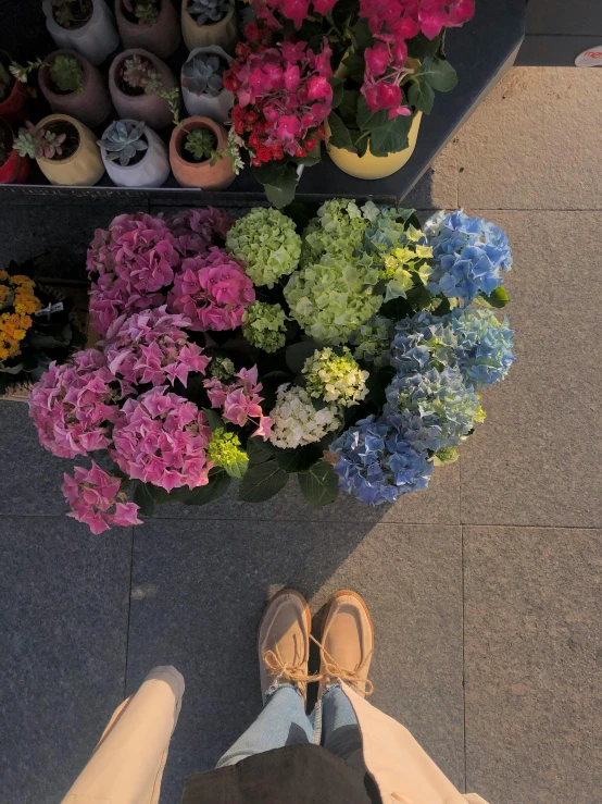 a person has their feet crossed by flowers in a flower shop