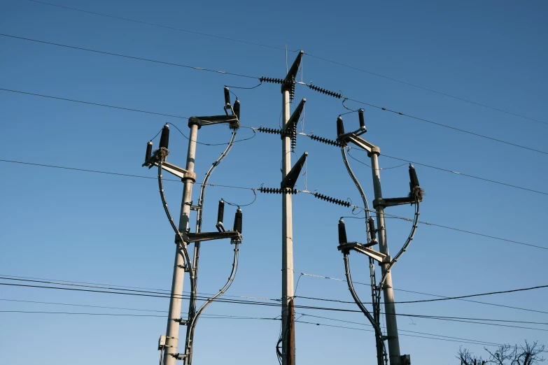 the top view of electrical wires and utility pole against the blue sky