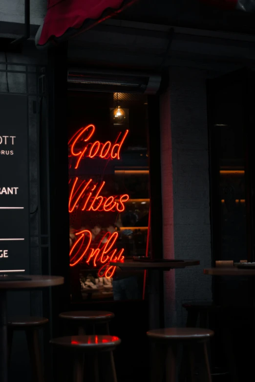 a neon sign advertises good vibes and dirty