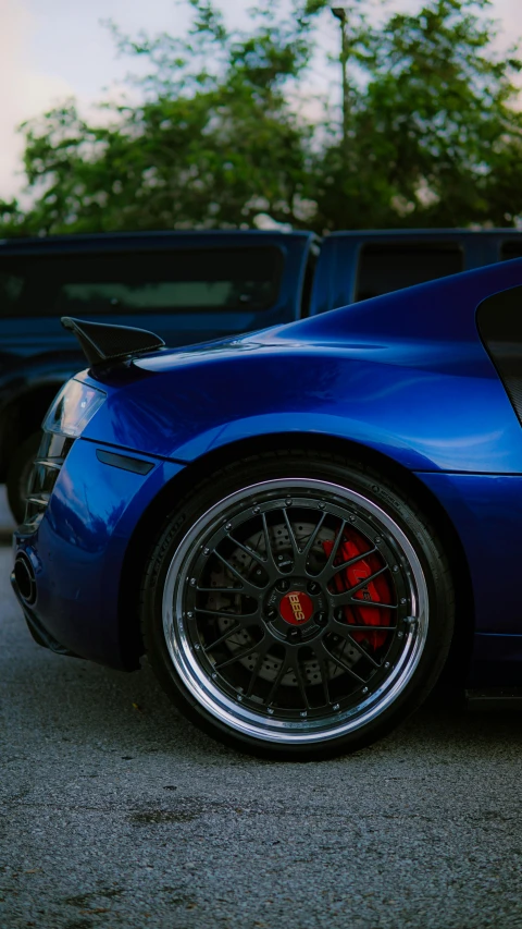 a blue sports car parked beside other cars