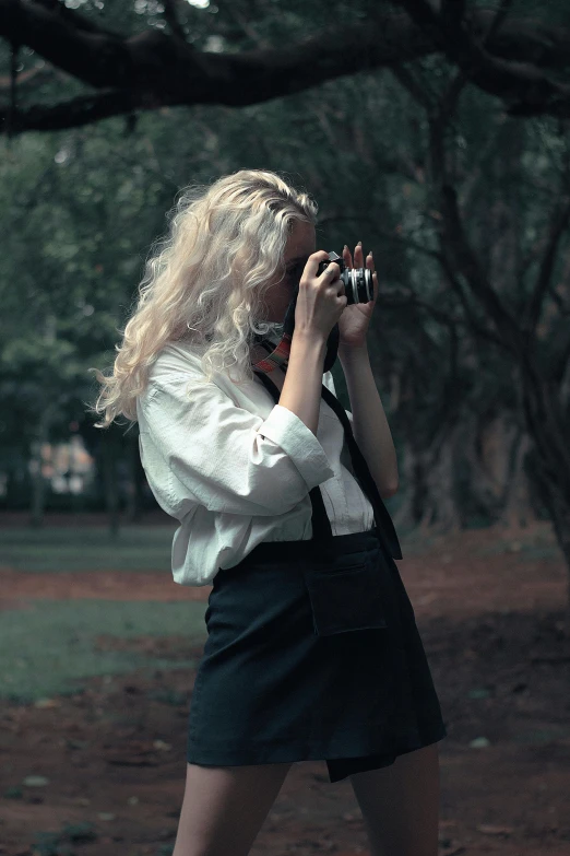 woman in an off - white shirt taking pictures with a camera