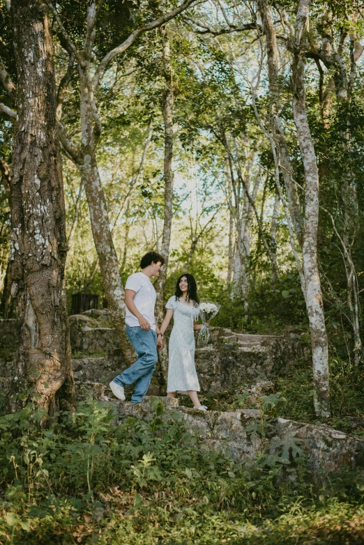 a young man and woman walking up stairs under trees